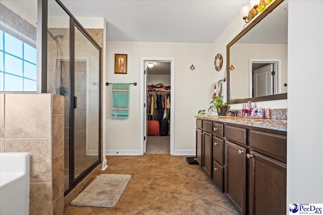 bathroom featuring tile patterned flooring, vanity, and walk in shower