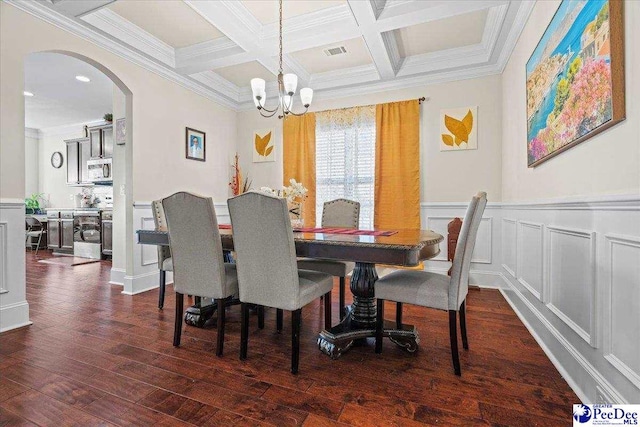 dining area with dark wood-type flooring, beam ceiling, a chandelier, and crown molding