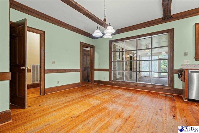 unfurnished dining area featuring light wood-style flooring, crown molding, a chandelier, and baseboards