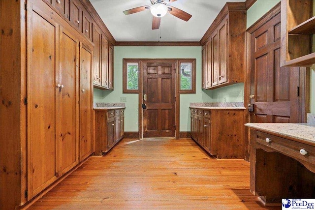laundry room with ceiling fan, light wood-style floors, baseboards, and ornamental molding