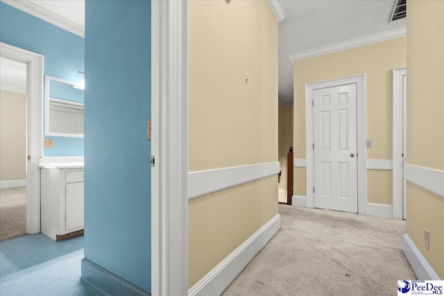 hallway with crown molding, carpet flooring, and baseboards