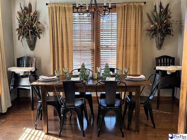 dining space with wood-type flooring and a notable chandelier