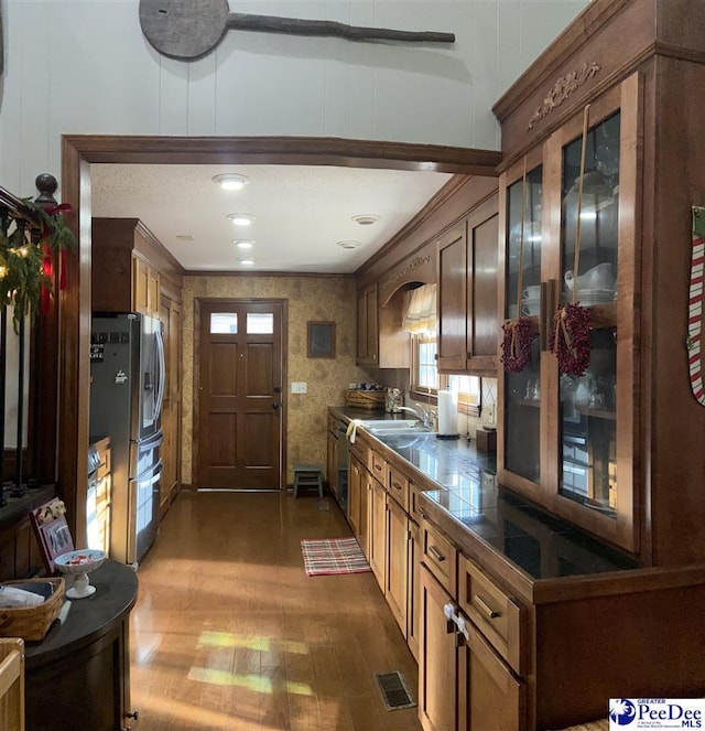 kitchen featuring dark wood-type flooring, ornamental molding, stainless steel appliances, and sink