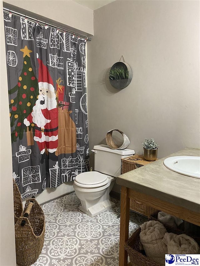 bathroom featuring vanity, toilet, and tile patterned flooring