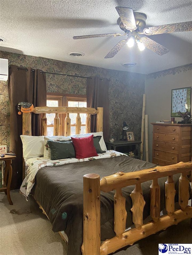 carpeted bedroom featuring ceiling fan, a wall mounted AC, and a textured ceiling