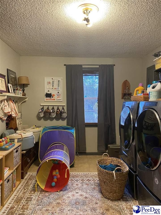 laundry room with tile patterned flooring, washer and dryer, and a textured ceiling