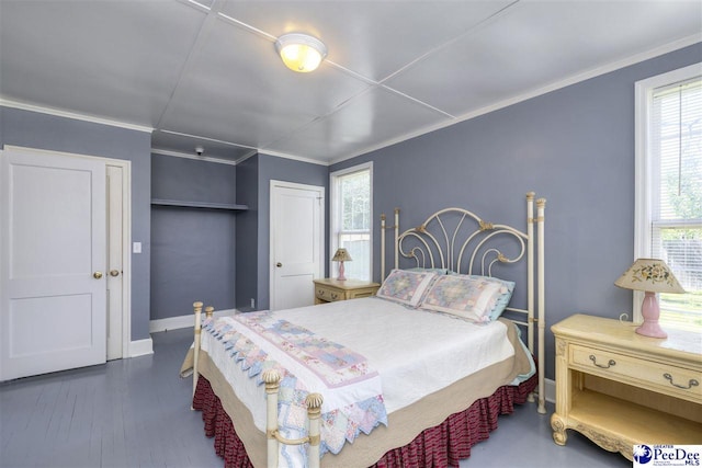 bedroom with baseboards, crown molding, and a closet