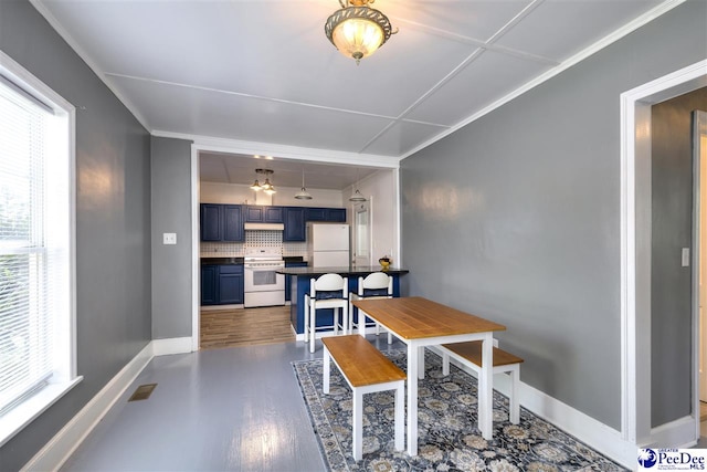 dining area featuring baseboards, wood finished floors, visible vents, and plenty of natural light