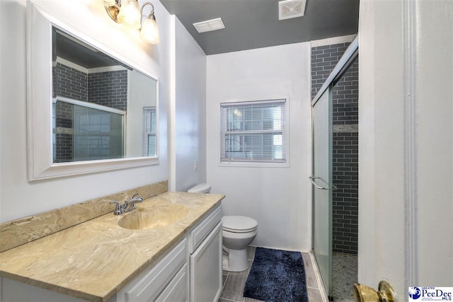 full bath with toilet, vanity, visible vents, and a stall shower