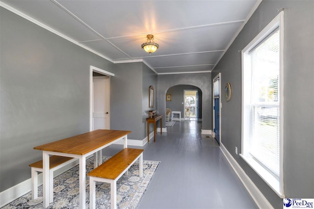 dining space featuring baseboards and arched walkways