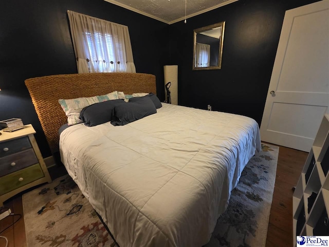 bedroom with wood finished floors and ornamental molding