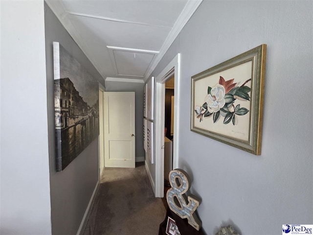 hall featuring attic access, dark carpet, ornamental molding, and baseboards