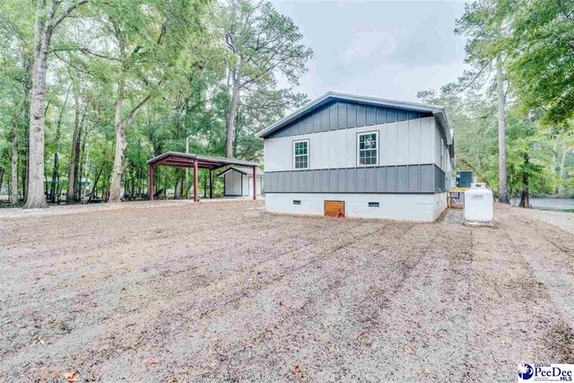 view of property exterior with cooling unit and a carport