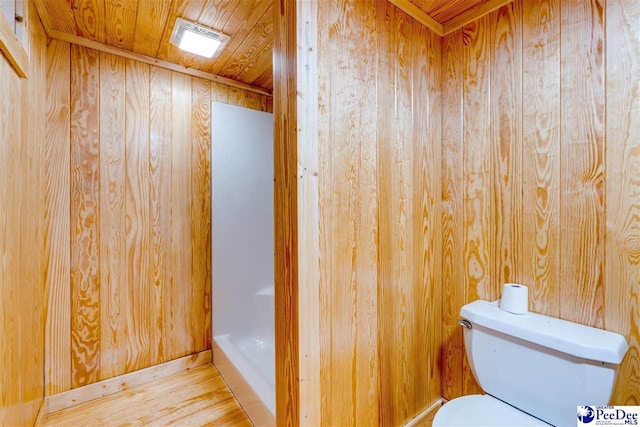 bathroom with hardwood / wood-style floors, wood walls, wood ceiling, and toilet