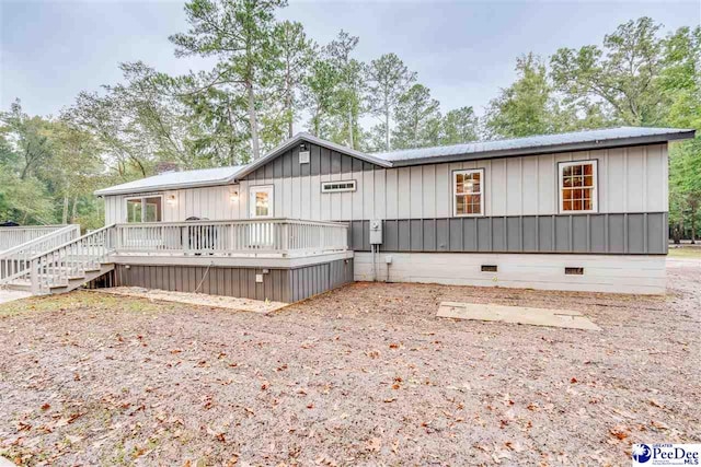 rear view of house featuring a wooden deck