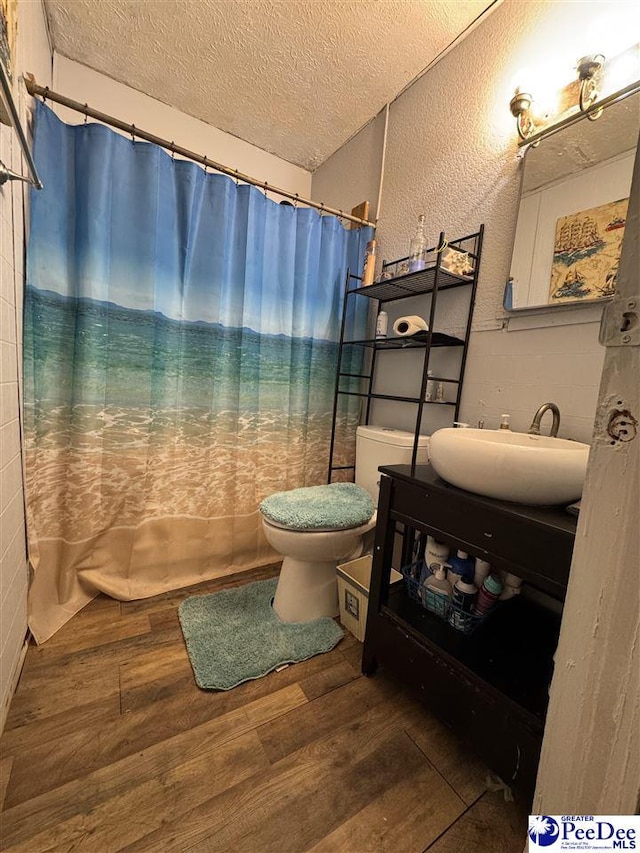 bathroom featuring hardwood / wood-style flooring, vanity, a textured ceiling, and toilet