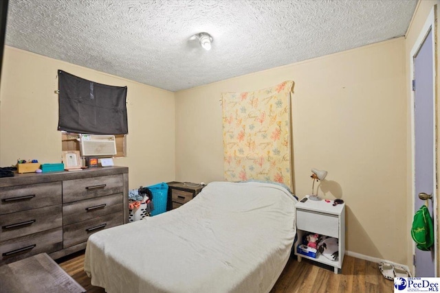 bedroom featuring hardwood / wood-style floors and a textured ceiling