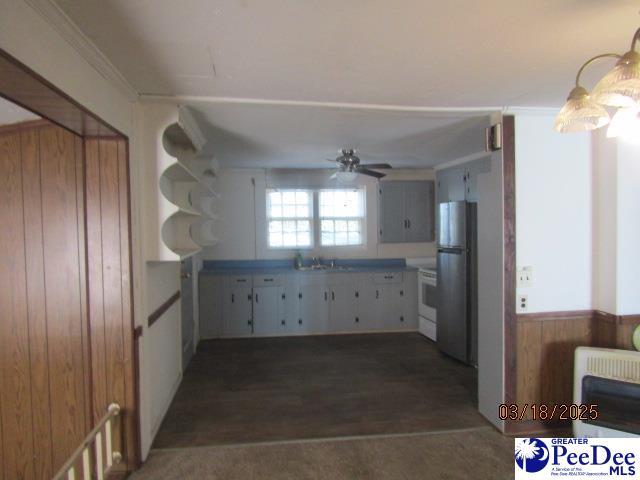 kitchen with white range with electric stovetop, heating unit, a ceiling fan, light countertops, and freestanding refrigerator