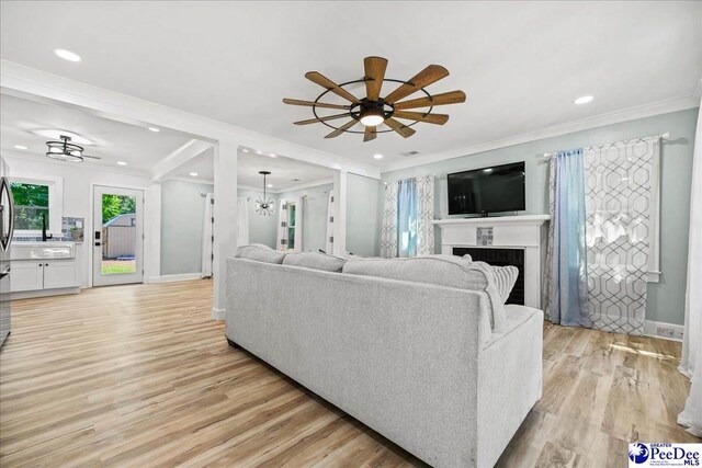 1314 Sewanee Ave, Florence, SC 29501 - living room featuring plenty of natural light, light wood-style flooring, ornamental molding, a fireplace, and ceiling fan