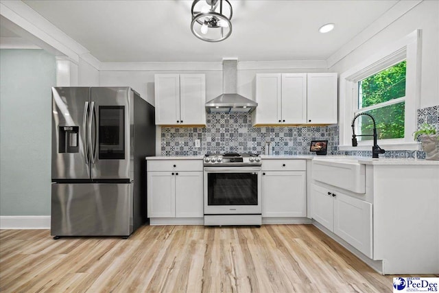 1314 Sewanee Ave, Florence, SC 29501 - kitchen featuring appliances with stainless steel finishes, wall chimney exhaust hood, a sink, light countertops, and white cabinetry