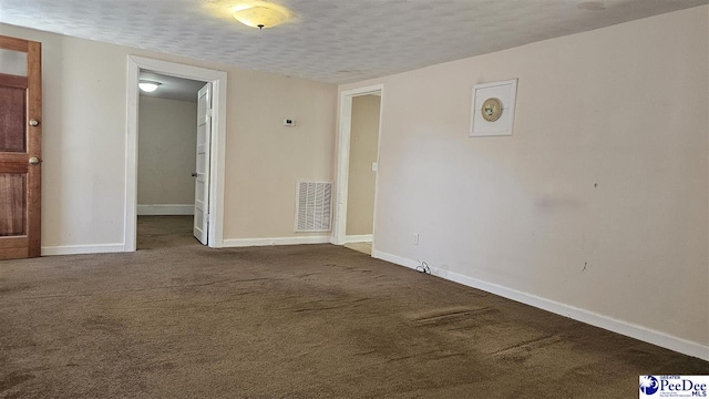 spare room featuring carpet floors and a textured ceiling