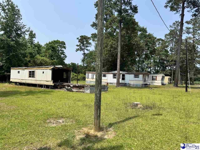 1515 Old Hamer Rd, Hamer, SC 29547 - view of front facade with a front yard, an outbuilding, and view of scattered trees