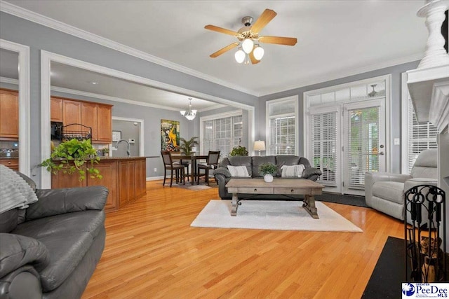 living room featuring crown molding, ceiling fan, sink, and light hardwood / wood-style flooring