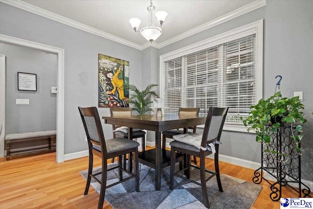 dining room featuring crown molding, wood-type flooring, and a notable chandelier