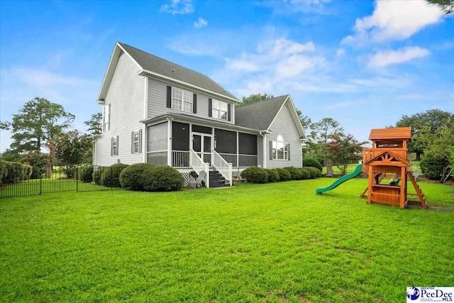 back of property with a yard, a playground, and a sunroom
