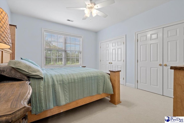 bedroom with multiple closets, carpet flooring, and ceiling fan