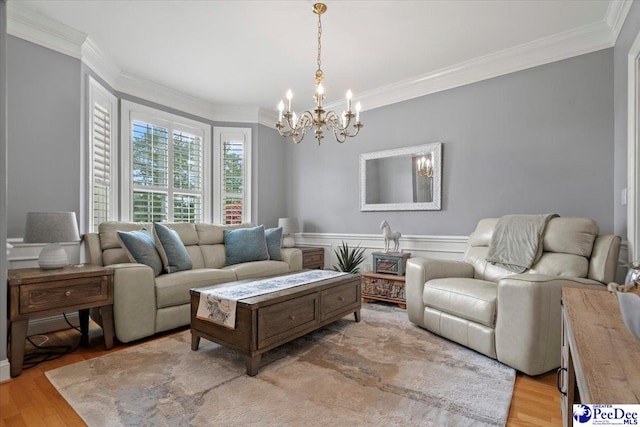 living room featuring ornamental molding, a chandelier, and light wood-type flooring