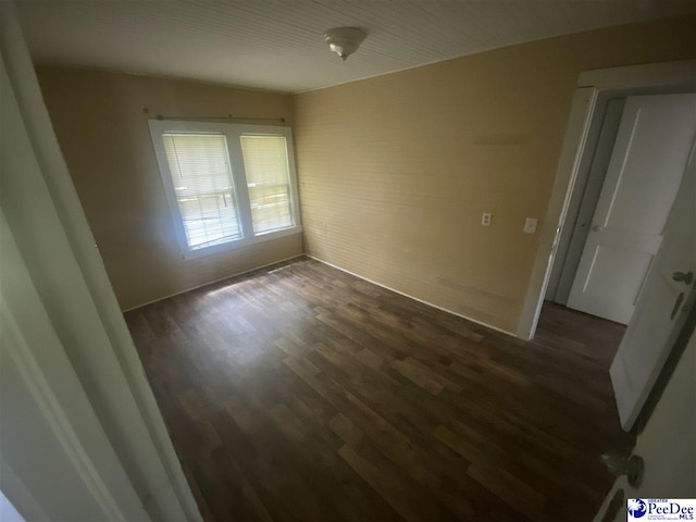 empty room featuring dark wood-type flooring