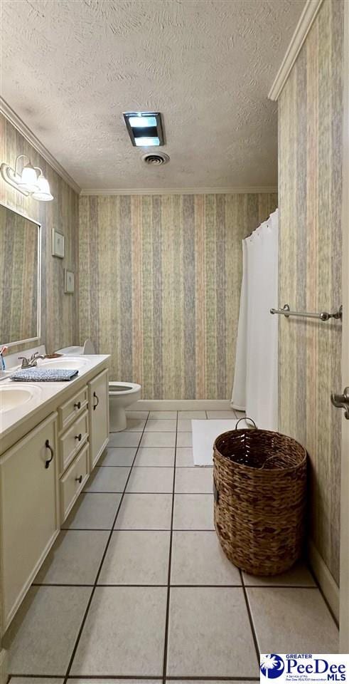 bathroom featuring toilet, vanity, tile patterned floors, a textured ceiling, and wallpapered walls