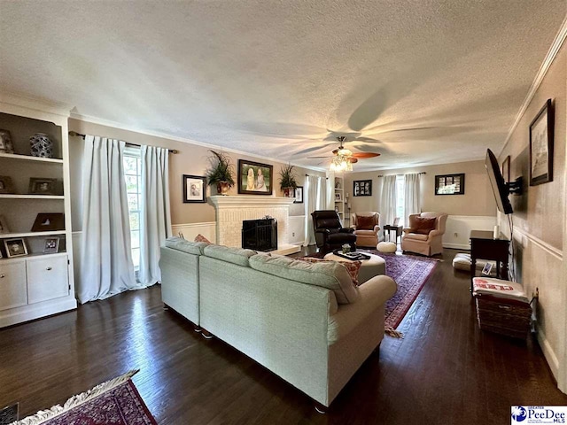 1217 Hillside Dr, Dillon, SC 29536 - living room with a brick fireplace, a ceiling fan, a textured ceiling, dark wood-style flooring, and ornamental molding