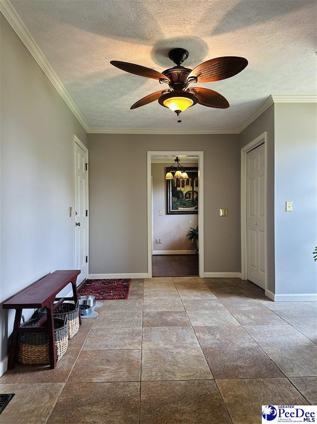 interior space with a textured ceiling, ornamental molding, and baseboards
