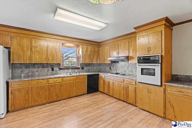 kitchen featuring sink, a textured ceiling, light wood-type flooring, white appliances, and backsplash