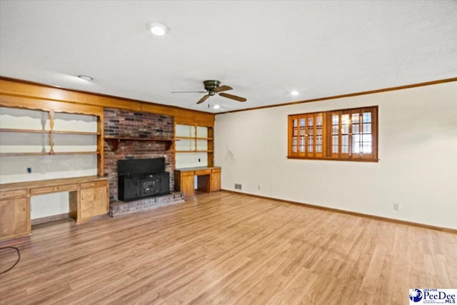 unfurnished living room with crown molding, ceiling fan, built in desk, and light wood-type flooring