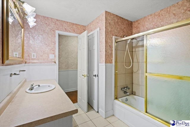 bathroom featuring tile patterned flooring, bath / shower combo with glass door, and vanity