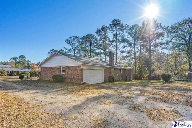 view of home's exterior featuring a garage and central AC unit