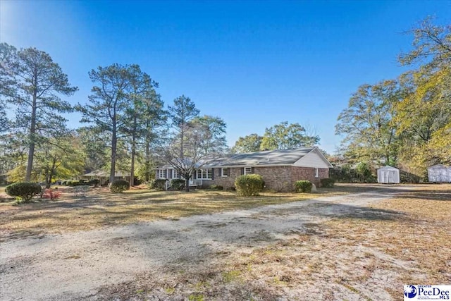 ranch-style house featuring a storage unit