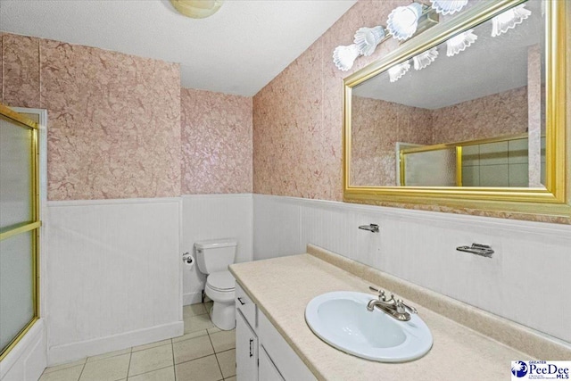 full bathroom with vanity, tile patterned flooring, shower / bath combination with glass door, and toilet