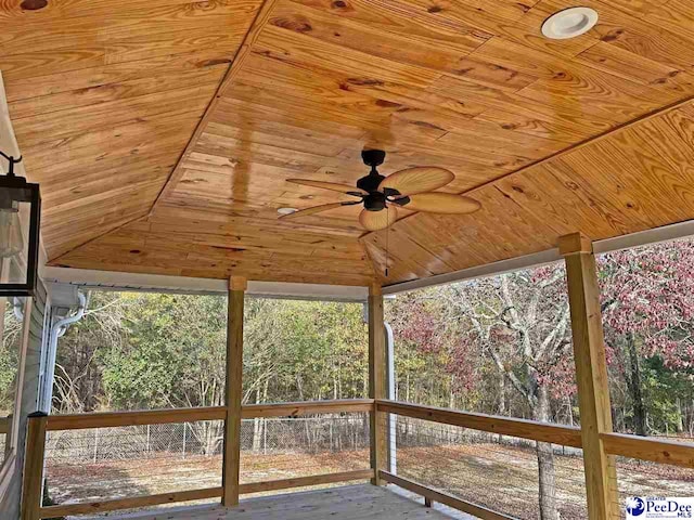 unfurnished sunroom featuring wood ceiling and ceiling fan