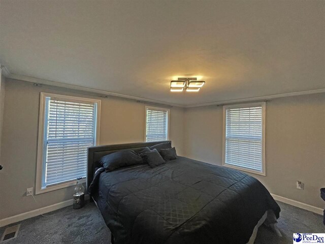 carpeted bedroom featuring multiple windows and ornamental molding