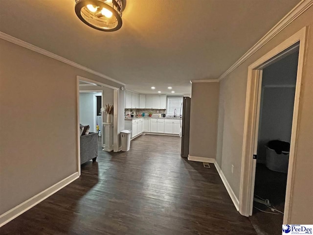 hall featuring dark hardwood / wood-style flooring, sink, and ornamental molding