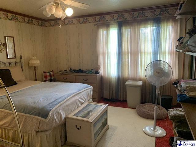 bedroom with ceiling fan and ornamental molding