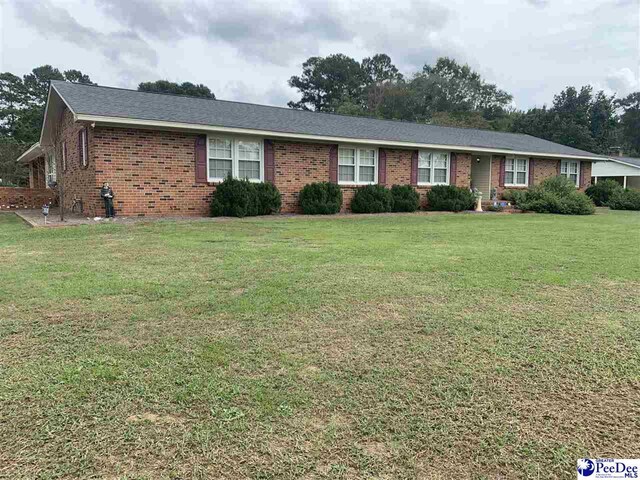 ranch-style home featuring a front lawn