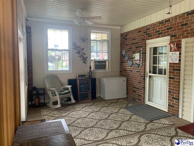 unfurnished sunroom with cooling unit and ceiling fan