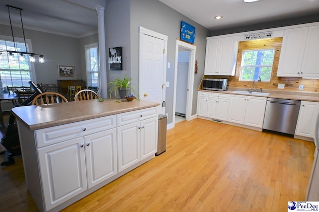 kitchen featuring appliances with stainless steel finishes, pendant lighting, sink, white cabinets, and light hardwood / wood-style flooring