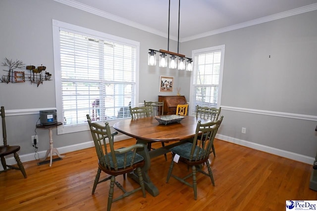 dining area with ornamental molding and hardwood / wood-style floors