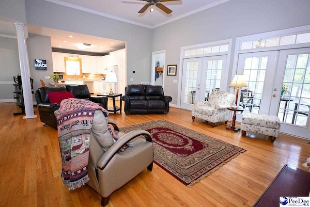 living room featuring crown molding, french doors, and light wood-type flooring